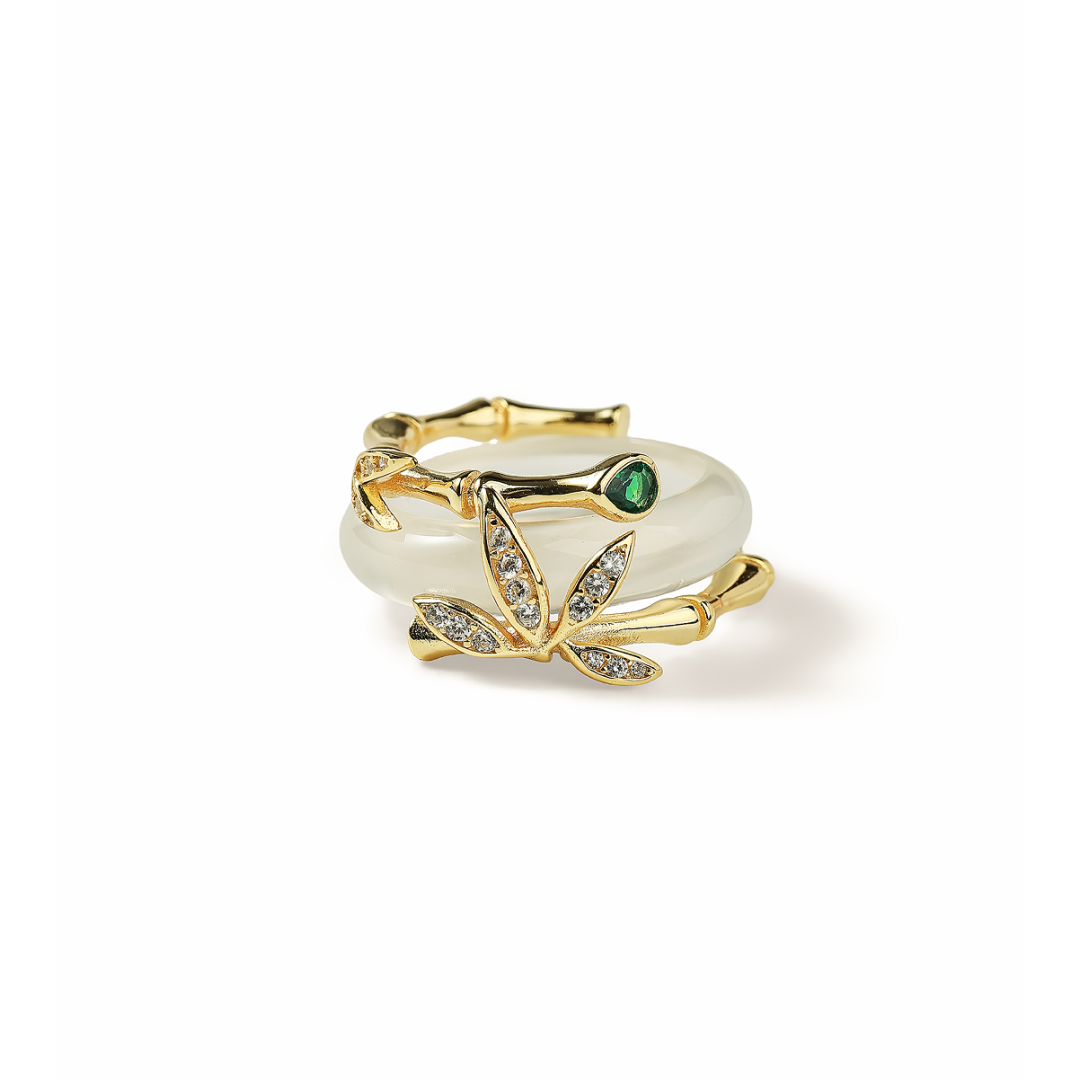 Aiko Tanaka ring angled view, a white jade band with a gold bamboo stalk and crystal leaves, white background