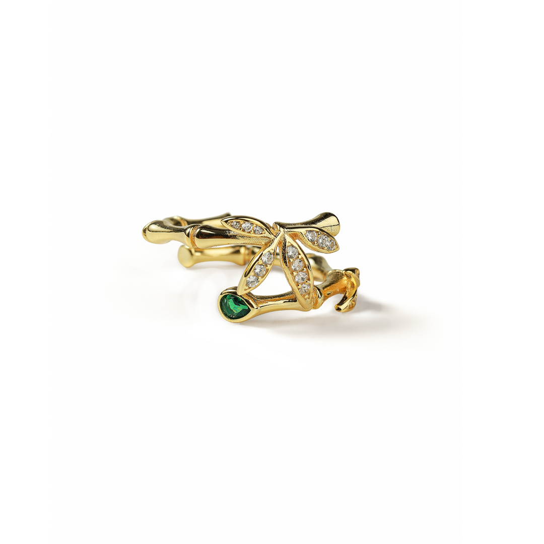 Aiko Tanaka ring part, a gold bamboo branch setting with crystal leaves and a green stone, on a white background